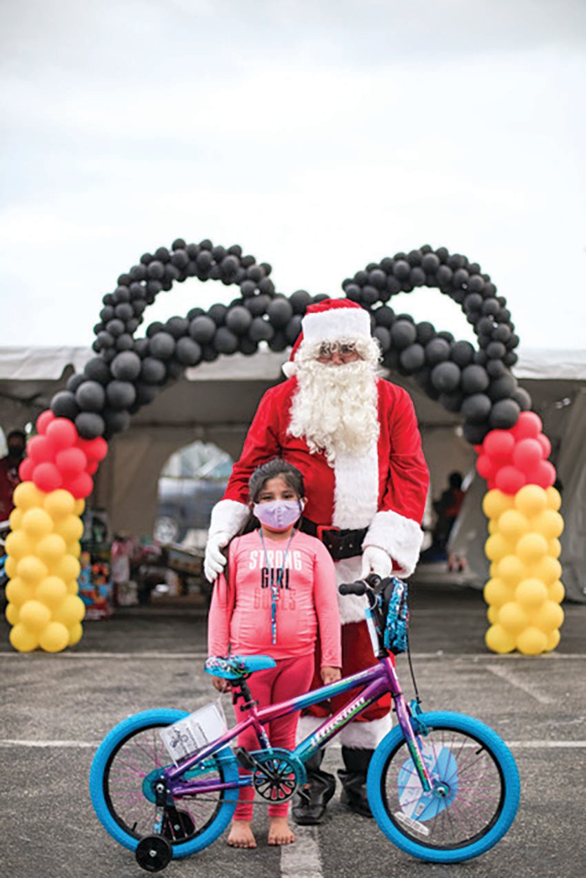 A mask can’t hide this girl’s joy of receiving a bike from Santa.